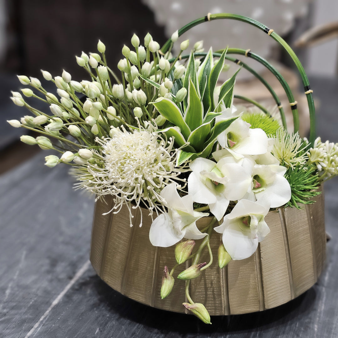 White Agapanthus, Protea, Horsetail Reeds and Dendrobium Orchid in Gold Metal Oval  11"H